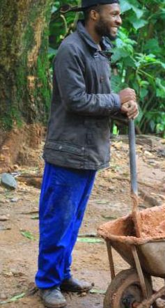 An ABA camper at work with a wheelbarrow and spade